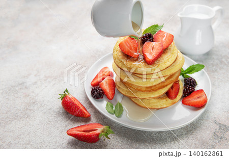 Pancakes with berries and syrup pouring for breakfast Pancakes with berries and syrup pouring for breakfast 140162861