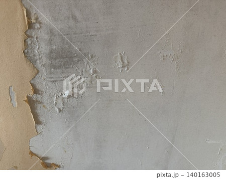 Peeling paint on a weathered wall creates a textured and aged background for design purposes 140163005