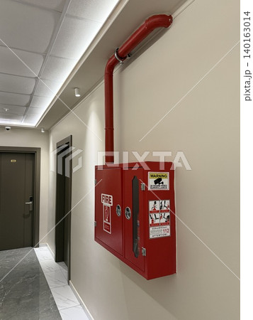 Fire safety box mounted on wall in a building hallway Fire safety box mounted on wall in a building hallway 140163014