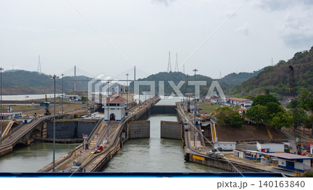 Colon, Panama - May 06, 2019: Waterway transportation. Ship at Gatun lake on the Panama canal. Waterway for sea ship transport. Opening gateway. Transport passing through Panama Canal Colon, Panama - May 06, 2019: Waterway transportation. Ship at Gatun lake on the Panama canal. Waterway for sea ship transport. Opening gateway. Transport passing through Panama Canal 140163840