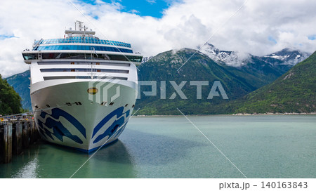 Skagway, Alaska, USA - July 23, 2019: Cruise ship vacation tour. Alaska harbor with cruise liner ship. Travel vacation tour. Travel destination. Island Princess of Princess cruises. Copy space Skagway, Alaska, USA - July 23, 2019: Cruise ship vacation tour. Alaska harbor with cruise liner ship. Travel vacation tour. Travel destination. Island Princess of Princess cruises. Copy space 140163843