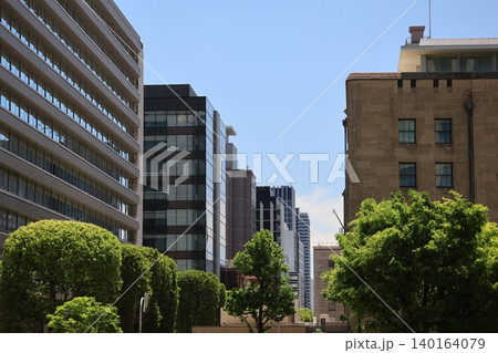 青空と高層ビルのビル群と緑の葉の街路樹のある風景 青空と高層ビルのビル群と緑の葉の街路樹のある風景 140164079