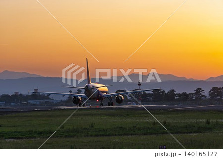 夕暮れの仙台空港 夕日とタキシング中の飛行機 宮城県名取市 夕暮れの仙台空港 夕日とタキシング中の飛行機 宮城県名取市 140165127
