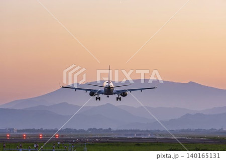 夕暮れの仙台空港　着陸中の飛行機と蔵王連峰　宮城県名取市 140165131