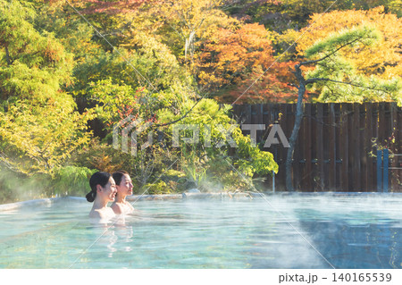 紅葉バックにのんびり露天風呂に入る女性 140165539