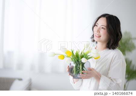 チューリップの花を持って笑顔を見せる女性の丁寧な暮らしのライフスタイルイメージ 140166874