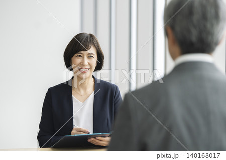 面接・面談 イメージ シニア男性と向き合って話をするビジネスウーマン 面接・面談 イメージ シニア男性と向き合って話をするビジネスウーマン 140168017