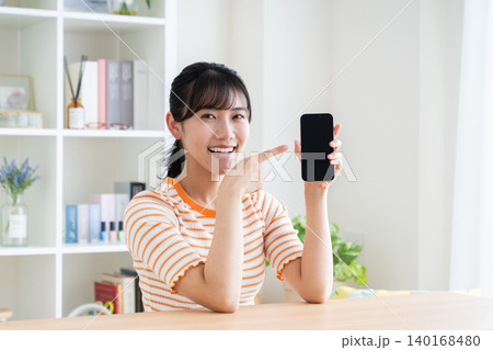 スマホをおすすめする若い女性 スマホをおすすめする若い女性 140168480