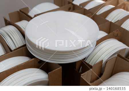 Boxes of white plates in crockery shop, dishware, tableware stack in store 140168535