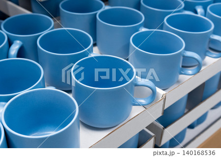 Blue cups and mugs in crockery shop, ceramic dishware, tableware stack in store Blue cups and mugs in crockery shop, ceramic dishware, tableware stack in store 140168536