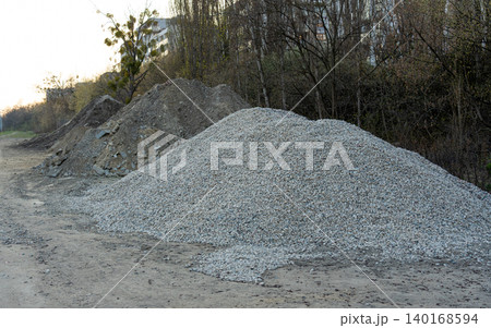 Construction gravel pile, crushed grey stone on ground Construction gravel pile, crushed grey stone on ground 140168594