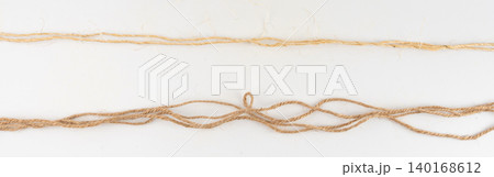 Twine rope piece isolated, jute loop fragment, beige packaging cord knots, old natural line cable 140168612