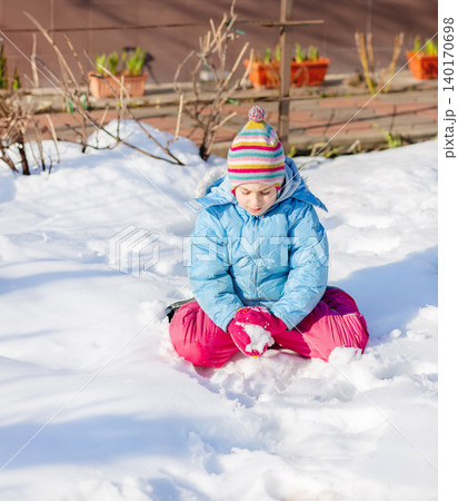 Smiling child in colorful winter clothes standing on snow  140170698