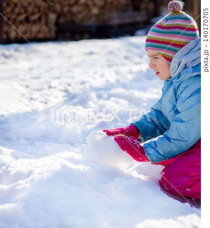 Smiling child in colorful winter clothes standing Smiling child in colorful winter clothes standing 140170705