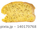 Single slice of fresh bread spread with creamy garlic butter and aromatic dried herbs, isolated. Top view close-up of a delicious toasted appetizer or side dish. 140170768
