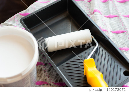 Paint roller and tray on table. Man is ready to do light makeover in his house. Home transformation. Creative home care concept 140172072