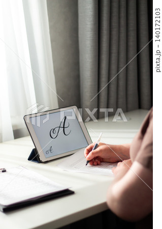 Person seated at desk deeply focused on writing in notebook. Physical engagement of motor skills Handwriting as brain training. Prevention of age related cognitive decline. Senior or adult practicing Person seated at desk deeply focused on writing in notebook. Physical engagement of motor skills Handwriting as brain training. Prevention of age related cognitive decline. Senior or adult practicing 140172103