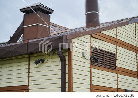 Charming wooden cottage with vibrant colors and stylish chimney in a serene countryside setting Charming wooden cottage with vibrant colors and stylish chimney in a serene countryside setting 140172239
