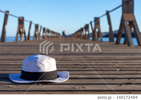 White Summer Hat with Black Ribbon on Beach Pier 140172484