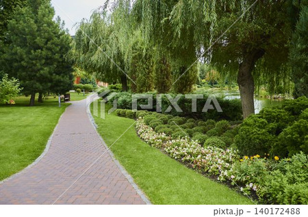 Scenic garden pathway inviting peaceful strolls amidst blooming flowers and lush greenery Scenic garden pathway inviting peaceful strolls amidst blooming flowers and lush greenery 140172488