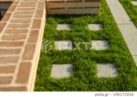 Beautiful garden path with stone tiles and grass 140172838