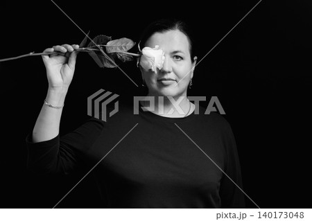 close up of a woman covering her eye with a white rose flower 140173048