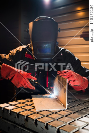 Welding sparks illuminate the dark workshop Welding sparks illuminate the dark workshop 140173184