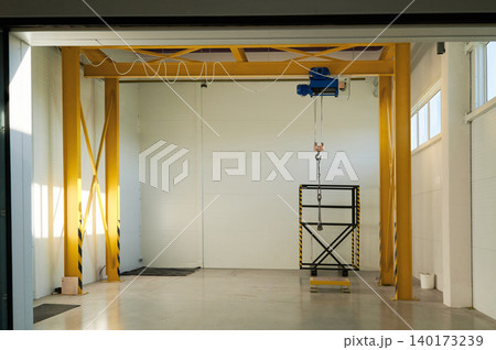 Bright industrial space with a hoist in use Bright industrial space with a hoist in use 140173239