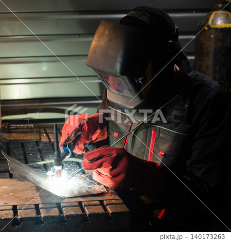 Welding sparks fly in a busy workshop Welding sparks fly in a busy workshop 140173263