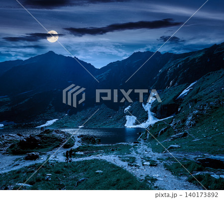 beautiful alpine scenery of fagaras mountains at night. full moon over lake in romania mountain landscape. summer weather with dark sky. rippled water near rocky slope. mysterious travel background beautiful alpine scenery of fagaras mountains at night. full moon over lake in romania mountain landscape. summer weather with dark sky. rippled water near rocky slope. mysterious travel background 140173892