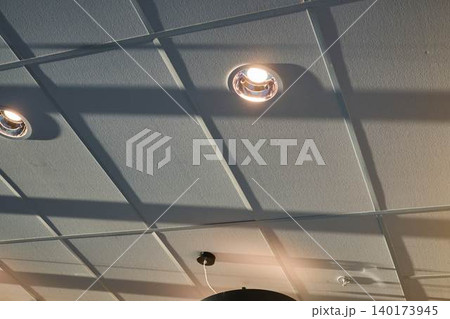 Unique Ceiling Design With Modern Lights Casting Intriguing Shadows in a Cafe Setting in Vibrant City Center 140173945