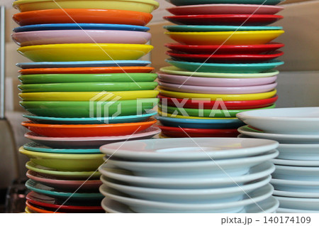 Multi colored plates stacked in columns according to size after a children's party  140174109