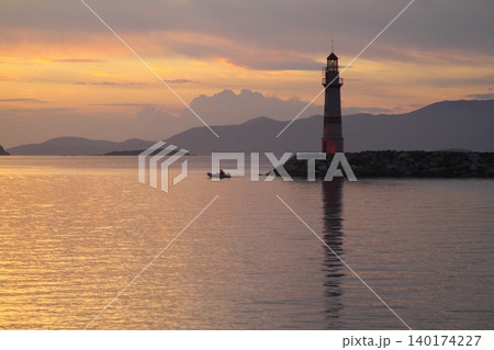 Seascape at sunshine. Lighthouse and sailings on the coast. Seaside town of Turgutreis and spectacular sunshine Seascape at sunshine. Lighthouse and sailings on the coast. Seaside town of Turgutreis and spectacular sunshine 140174227