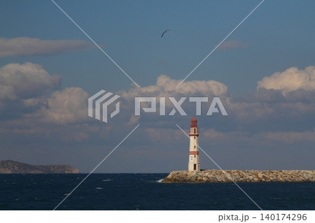 Seascape at sunshine. Lighthouse and sailings on the coast. Seaside town of Turgutreis and spectacular sunshine 140174296