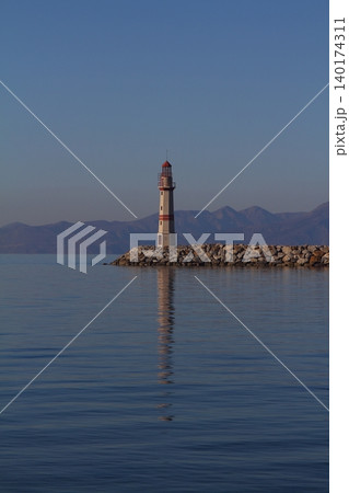 Seascape at sunshine. Lighthouse and sailings on the coast. Seaside town of Turgutreis and spectacular sunshine Seascape at sunshine. Lighthouse and sailings on the coast. Seaside town of Turgutreis and spectacular sunshine 140174311