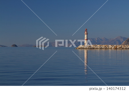Seascape at sunshine. Lighthouse and sailings on the coast. Seaside town of Turgutreis and spectacular sunshine Seascape at sunshine. Lighthouse and sailings on the coast. Seaside town of Turgutreis and spectacular sunshine 140174312