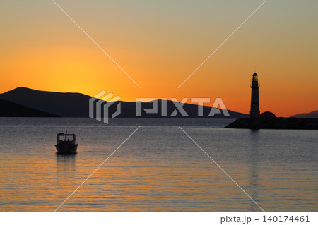 Seascape at sunshine. Lighthouse and sailings on the coast. Seaside town of Turgutreis and spectacular sunshine Seascape at sunshine. Lighthouse and sailings on the coast. Seaside town of Turgutreis and spectacular sunshine 140174461