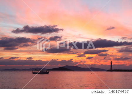 Seascape at sunshine. Lighthouse and sailings on the coast. Seaside town of Turgutreis and spectacular sunshine Seascape at sunshine. Lighthouse and sailings on the coast. Seaside town of Turgutreis and spectacular sunshine 140174497