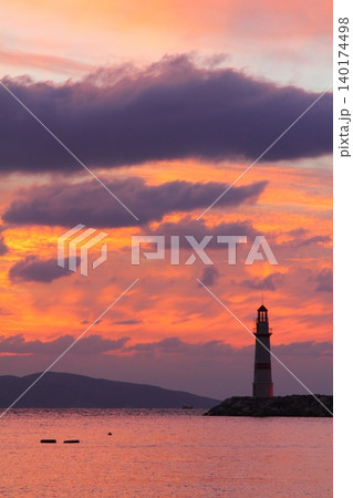 Seascape at sunshine. Lighthouse and sailings on the coast. Seaside town of Turgutreis and spectacular sunshine Seascape at sunshine. Lighthouse and sailings on the coast. Seaside town of Turgutreis and spectacular sunshine 140174498