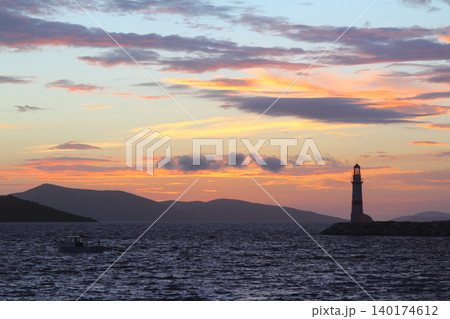 Seascape at sunshine. Lighthouse and sailings on the coast. Seaside town of Turgutreis and spectacular sunshine Seascape at sunshine. Lighthouse and sailings on the coast. Seaside town of Turgutreis and spectacular sunshine 140174612