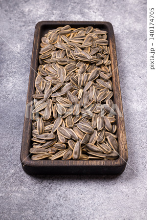 Sunflower seeds filling wooden bowl with healthy snack 140174705