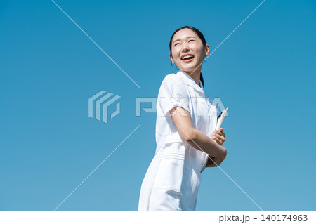 青空を背景に立つ看護師の若い女性 青空を背景に立つ看護師の若い女性 140174963
