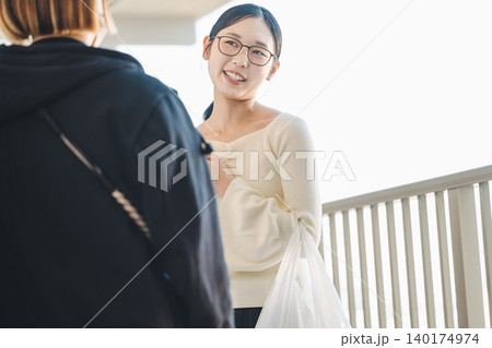 マンションの通路でママ友と世間話をする若い女性 マンションの通路でママ友と世間話をする若い女性 140174974