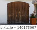 Weathered Arched Wooden Door on Historic Bavarian Wall 140175067
