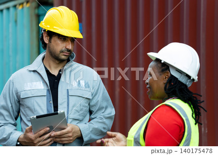 Logistics supervisors discussing cargo operations with digital tablet at shipping container yard, showcasing industrial teamwork, workplace communication and modern supply chain coordination Logistics supervisors discussing cargo operations with digital tablet at shipping container yard, showcasing industrial teamwork, workplace communication and modern supply chain coordination 140175478