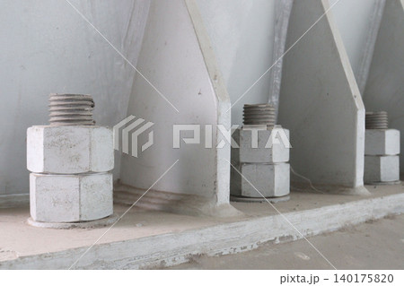 The image features large, thick anchor bolts The image features large, thick anchor bolts 140175820