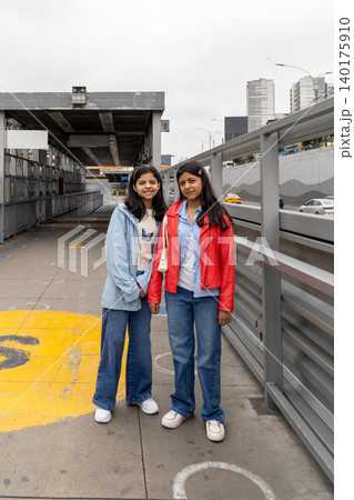 Two teenagers in blue and red jackets pose for a picture Two teenagers in blue and red jackets pose for a picture 140175910