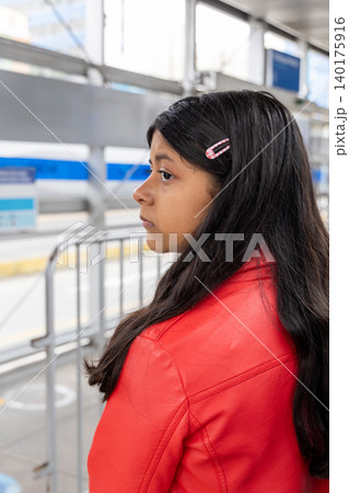 A teenager with long hair is wearing a red jacket and pink hair clips A teenager with long hair is wearing a red jacket and pink hair clips 140175916