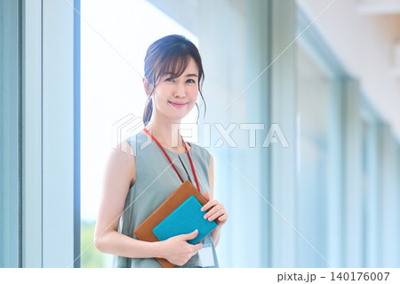 社員証を下げ手帳を抱えて微笑むオフィスウーマン 社員証を下げ手帳を抱えて微笑むオフィスウーマン 140176007