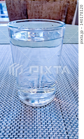 close-up photo of a glass of water on a white table 140178120